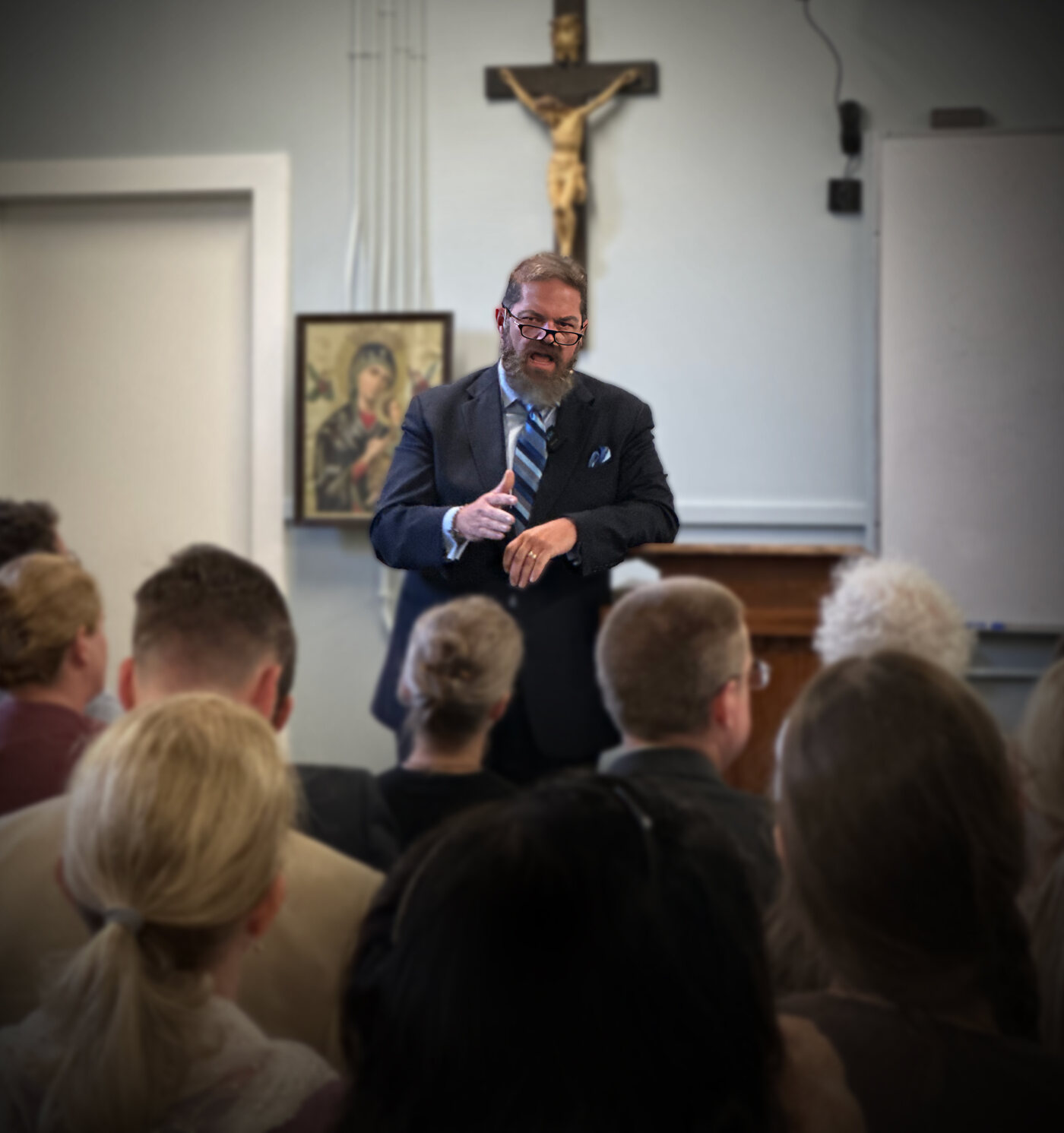 Joe McClane preaching beneath the crucifix at a parish mission